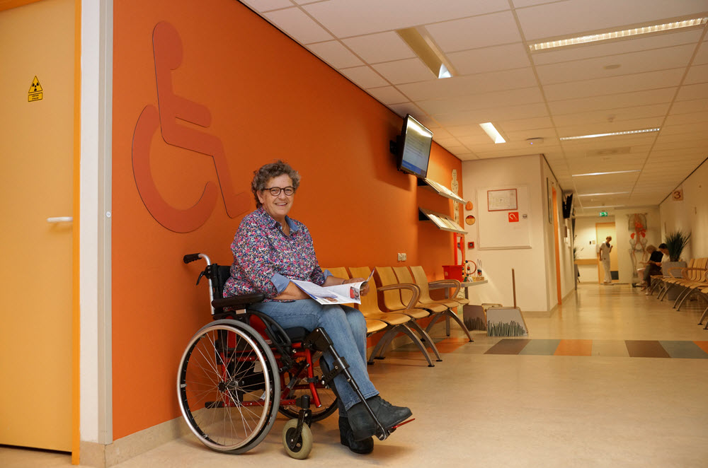 Wilke van de Horst, lid van de PatiÃ«ntenraad van St Jansdal, laat zien dat de rolstoelplaats een aanwinst is.