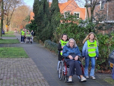 Leerlingen van groep 7 van CDS Willem Alexander wandelen met bewoners van Boerhaavehof